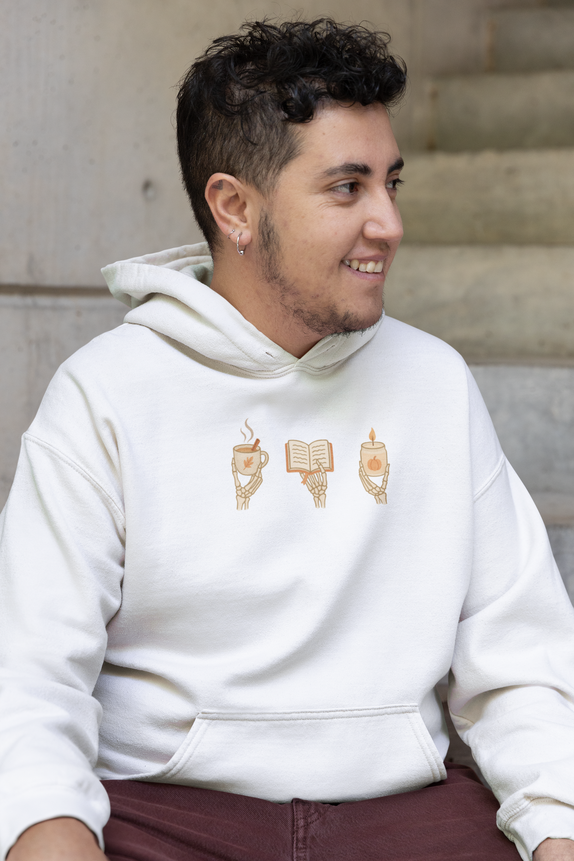 Adult hoodie in white with 'Cozy Bones' graphic print. Fall & halloween themed graphic sweatshirts. 