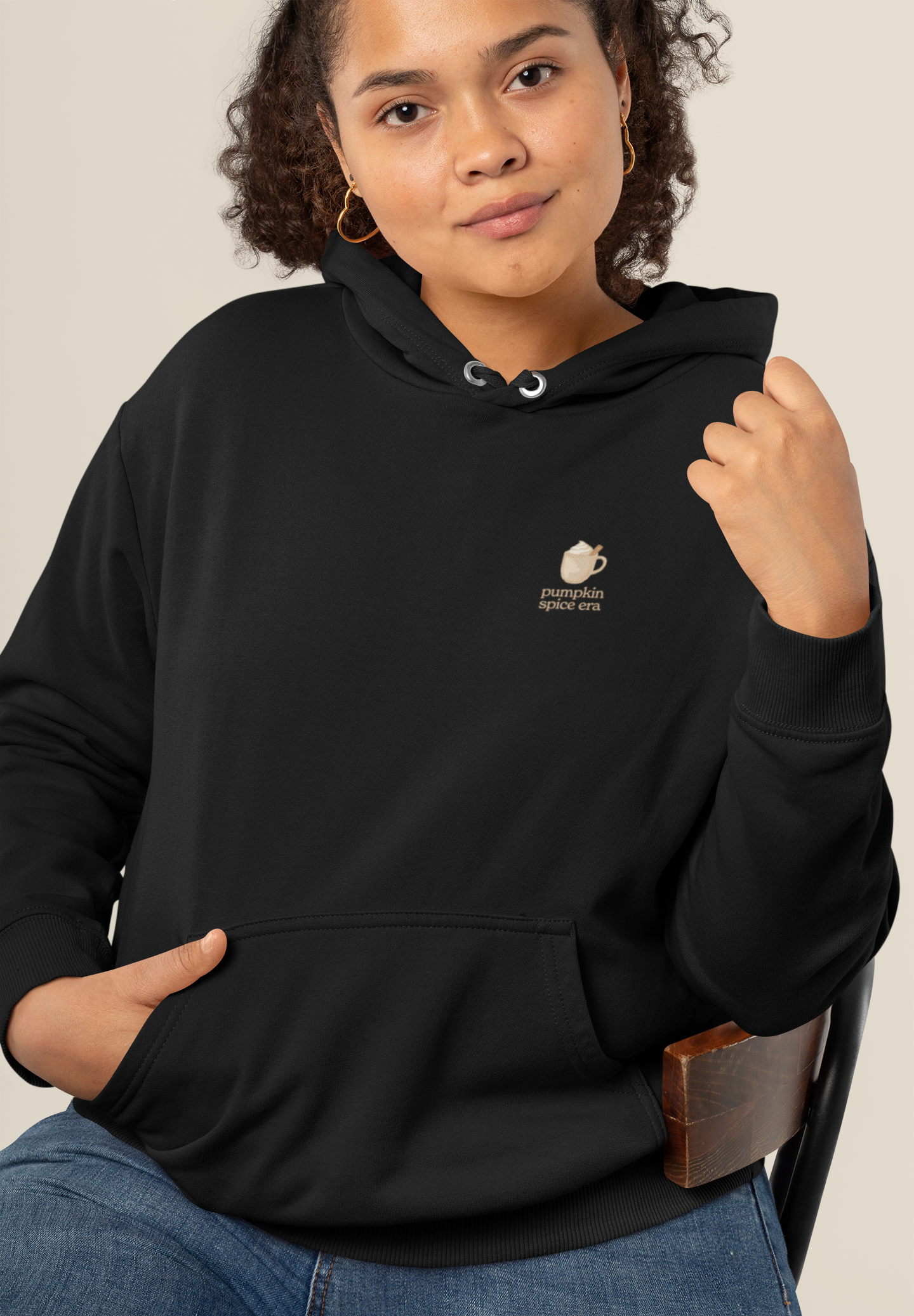 Adult hoodie in black with 'Pumpkin Spice Era' graphic print. Fall & pumpkin themed graphic sweatshirts. 