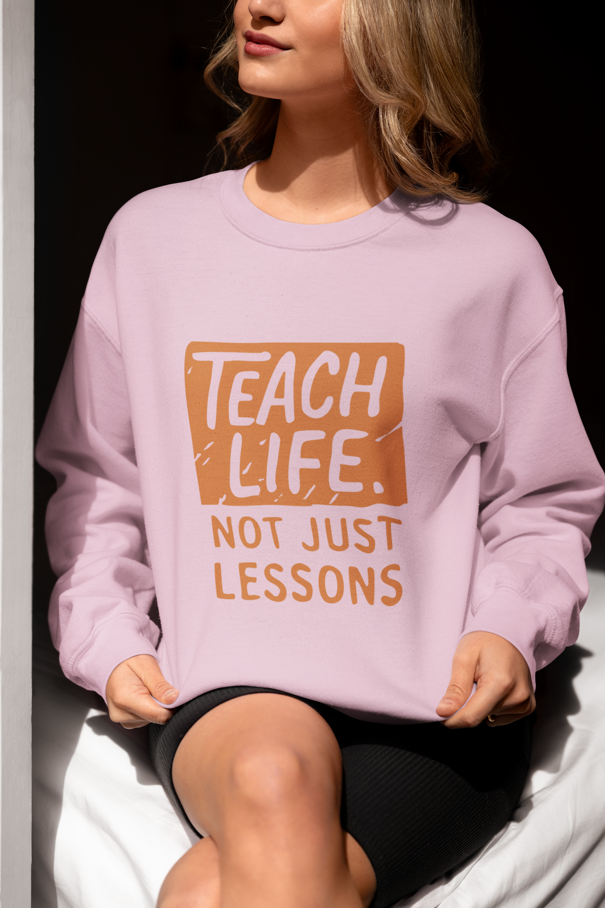 Adult sweatshirt in pink with 'Teach Life, Not Just Lessons' graphic print.  Teacher & education themed graphic tees for homeschoolers.